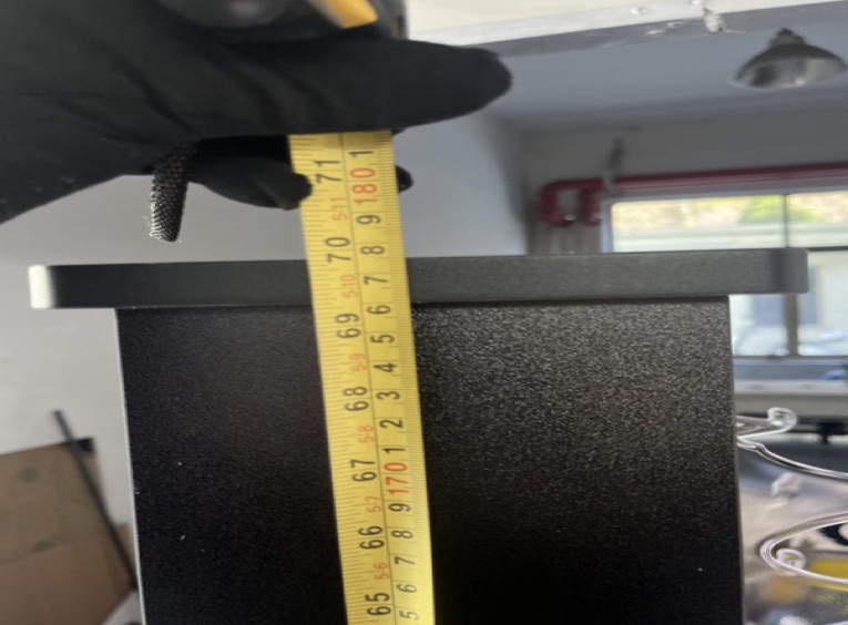 An inspector measuring a product with a tape measure